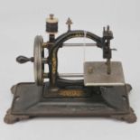 A Victorian black painted and gilt decorated table-top sewing machine, on cast iron base, w.33cm