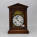 A late 19th century continental stained pine cased mantel clock, of architectural form, the arched