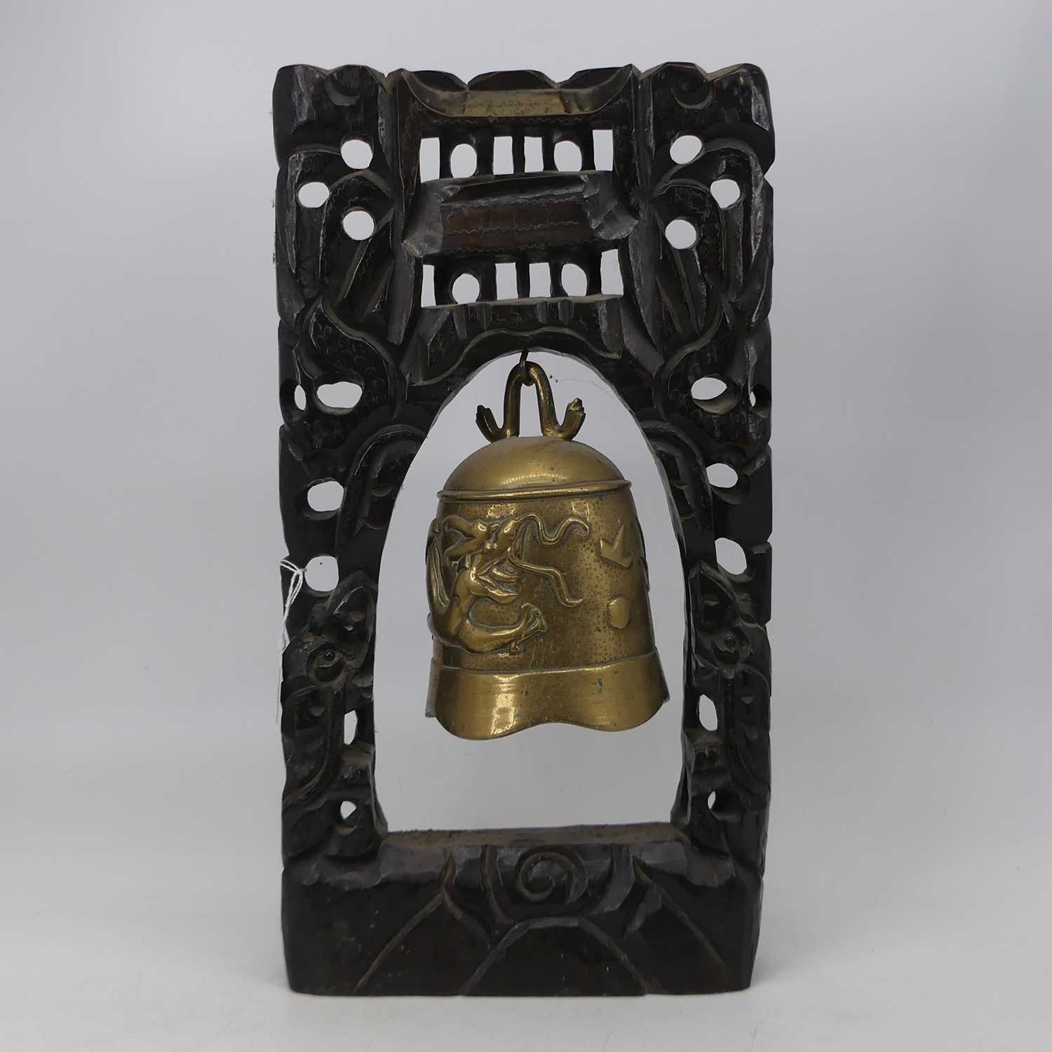 A 20th century temple bell, relief decorated with a dragon, suspended from a carved and pierced