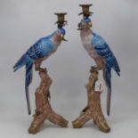 A pair of modern Continental table candlesticks, each in the form of a parrot perched on a treestump