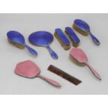 A collection of seven enamel decorated silver dressing table hand brushes and mirrors