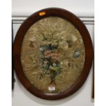 A 19th century silk panel embroidered as a bouquet of flowers within oak oval frame, 45x37cm