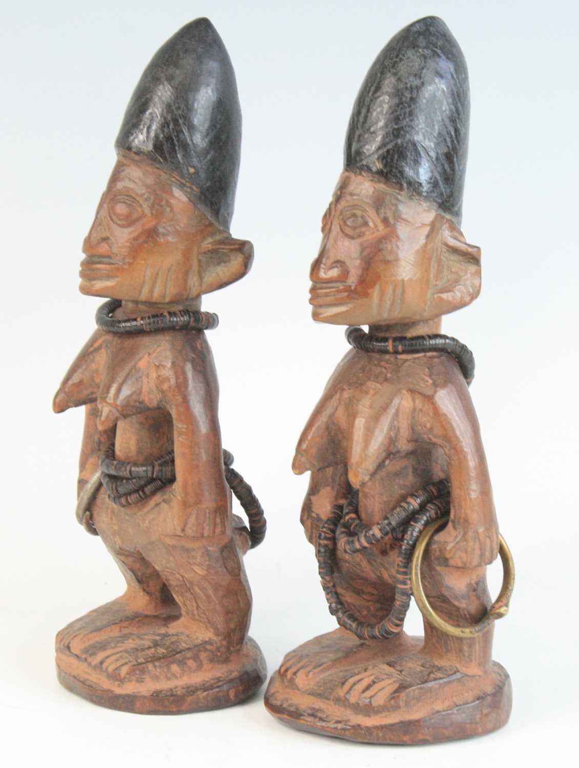 A pair of Ibeji figures, each carved as a female in standing pose with scarified cheeks and - Image 2 of 5