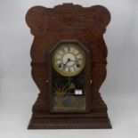 A late 19th century American walnut cased gingerbread mantel clock, having carved surround with