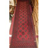 A Persian style machine woven red ground Bokhara hall runner, 295 x 80cm