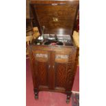 A 1930s 'His Master's Voice' oak freestanding gramophone, the hinged cover with gramophone deck over