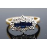 An 18ct yellow and white gold, sapphire and diamond lozenge shaped cluster ring, featuring three