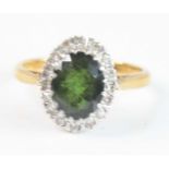 An 18ct yellow and white gold, tourmaline and sapphire oval cluster ring, featuring a centre oval