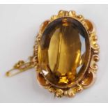 A yellow metal citrine brooch, the oval facetted citrine measuting 29 by 21.1 by 11.7mm approx.