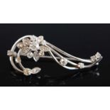 An 18ct white gold diamond flower brooch comprising 19 Old European cut diamonds in claw settings