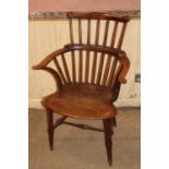An early 19th century provincial elm and beech comb back Windsor chair, having a pronounced dish