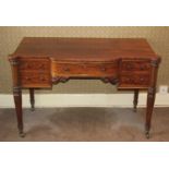 A Victorian plum pudding mahogany kneehole dressing table, having a bowfront centre drawer flanked