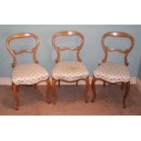 A set of three mid-Victorian maple balloon back salon chairs, each with floral upholstered stuffover