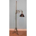 A lacquered and painted wrought iron standard lamp, the branch arm with rise-and-fall action, on