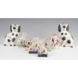 A pair of Victorian Staffordshire models of cats, sponge decorated in black and ochre, h.10.5cm,