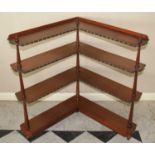A Victorian mahogany four-tier open corner bookshelf, raised on turned supports with brass studded