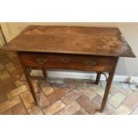 An 18th century provincial joined yew and oak plank topped single drawer side table, raised on