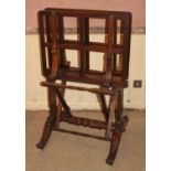 An early Victorian rosewood folio stand, having typical opposing hinged action, raised on lyre end