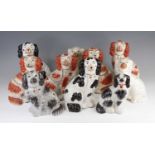 A collection of ten Victorian Staffordshire models of spaniels, each shown in seated pose, largest