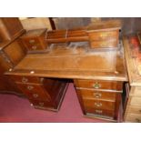 A late Victorian mahogany kneehole writing desk, having a raised integral superstructure, gilt