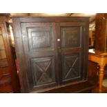 An antique oak double door side cupboard, bearing a line carved date 1672 and monogramed NIM,