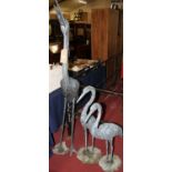 A large cast metal freestanding garden statue of a crane, h.173.5cm; together with two similar