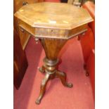 A mid-Victorian figured walnut octagonal hinge top sewing table, raised on floral carved hip