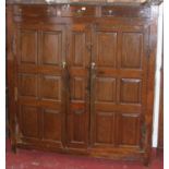 An 18th century joined and panelled oak double door side cupboard, having three short upper