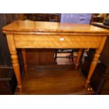 A mid-Victorian satinwood round cornered fold-over tea table, raised on turned slightly tapering