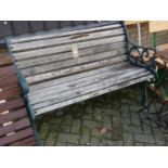 A pierced and painted wrought iron ended and teak slatted two-seater garden bench, width 128.5cm