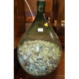 A green glass carboy, containing a large quantity of shells, height 52.5cm