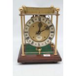 A Thwaites & Reed rolling ball clock, the open movement with silvered dial and named plaque with