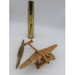 A copper desk ornament in the form of an aeroplane, 28cm; together with a brass shell case; and a