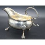 A 19th century silver sauce boat having a wavy rim with acanthus capped flying C-scroll handle,
