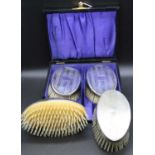 A pair of George V silver clothes brushes, each of oval form with engine turned decoration and in