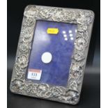 A George V silver clad easel photograph frame, the rectangular frame relief decorated with lily pads