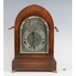 An Edwardian Peerless mahogany cased bracket clock, the Gothic influence case with brass carry