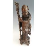 A large 19th century Chinese carved hardwood (possibly hongmu) figure of Shoulao, in typical