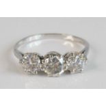 A white metal diamond trilogy ring, featuring three round brilliant cut diamonds in claw settings,