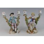 A pair of Meissen porcelain figural twin branch table candlesticks, late 19th century, each shown in