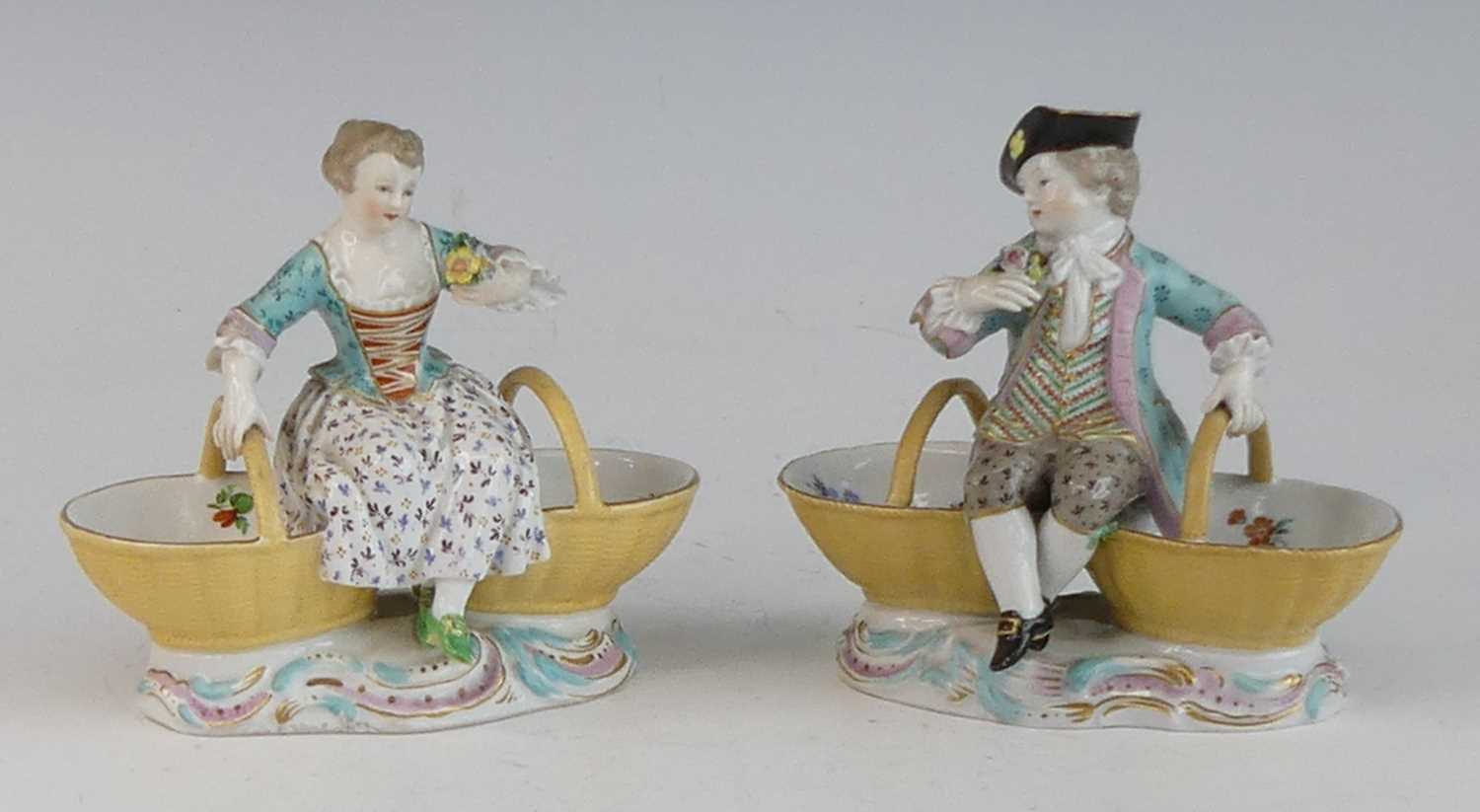 A pair of Meissen porcelain figural table salts, late 19th century, each shown in 18th century
