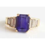 A yellow metal, tanzanite and diamond ring, featuring a centre rectangular cut tanzanite with