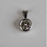 A white metal diamond single stone pendant, the round brilliant cut diamond in a bezel setting