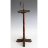 A 17th century wrought iron rush light holder, on probably associated turned oak stand, h.76cm