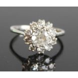 A white metal diamond circular cluster ring, comprising a centre transitional brilliant cut