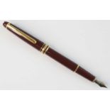A Montblanc Meisterstück fountain pen, burgundy resin with gold-coated trim, the cap with white star