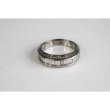 A white metal diamond half hoop eternity ring, comprising a centre row of 18 baguette cut diamonds