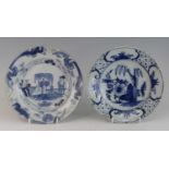 A Delft blue and white plate, 18th century, decorated with a figure within a fenced garden, dia.23.