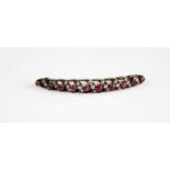 A yellow and white metal, ruby and diamond curved bar brooch, comprising ten graduated round