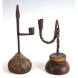 A 17th century wrought iron rush light holder, on turned wooden base, h.24cm; together with one